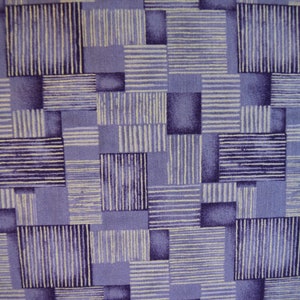 May include: A purple fabric with a geometric pattern of white and purple stripes. The fabric is made up of squares and rectangles.