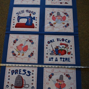 May include: A blue fabric panel with eight white squares, each featuring a different sewing-themed design. The squares have red and white borders and contain images of sewing tools, buttons, and birds. The text on the squares includes "Sew Good", "Who's got the button", "One Block at a Time", and "Press with care".