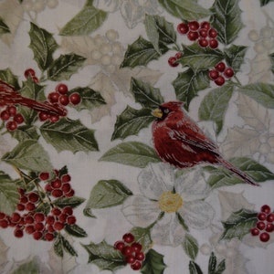 May include: White fabric with a repeating pattern of red cardinals, holly leaves, and white flowers. The cardinals are perched on branches and have red beaks and black eyes.