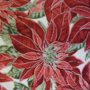 May include: Red and green poinsettia floral print fabric. The fabric features a white background with red poinsettia flowers and green leaves.