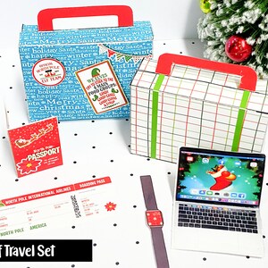 May include: A miniature Elf Travel Set featuring two suitcases, a passport, a boarding pass, a smartwatch, and a laptop. The suitcases have red handles and are decorated with holiday-themed patterns and stickers. The laptop displays a Christmas scene.