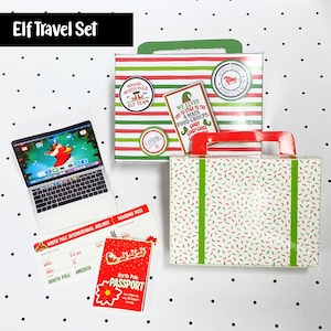 May include: An "Elf Travel Set" with a laptop, passport, boarding pass, and two suitcases. The suitcases have red and green accents, and the laptop displays Santa Claus. The passport reads "North Pole Passport". The boarding pass is for North Pole International Airlines.