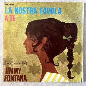May include: Vintage vinyl record cover featuring the text "LA NOSTRA FAVOLA A TE" in blue and red. The cover art includes a profile of a woman with dark hair and a green bow, with the artist's name, Jimmy Fontana, below.