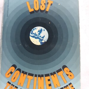 May include: A book cover with a blue and white globe surrounded by concentric circles in shades of blue. The title "LOST CONTINENTS" is in orange letters.