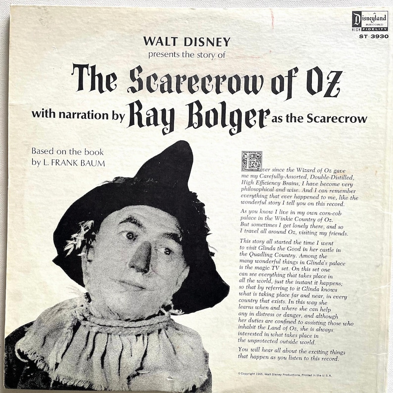 May include: Vintage Disneyland record album cover featuring Ray Bolger as the Scarecrow from "The Scarecrow of Oz." The cover has a black and white image of Ray Bolger in character, with text in a classic Disney font. The album is based on the book by L. Frank Baum.