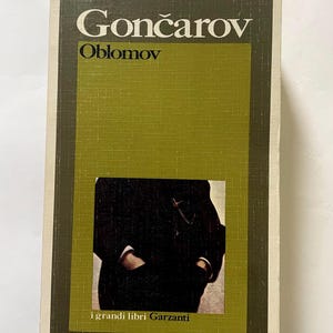 May include: A hardcover book titled "Goncarov Oblomov" with a green and brown cover. The cover features the title in white and a dark image of a person. The text "i grandi libri Garzanti" is at the bottom.