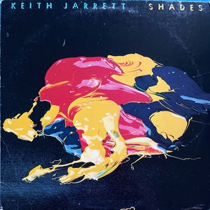Może przedstawiać: Czarna okładka winylowego albumu z tekstem "Keith Jarrett Shades" w białych literach. Okładka przedstawia abstrakcyjny wzór z żółtych, czerwonych i niebieskich plam farby na czarnym tle.