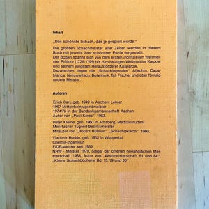May include: A yellow and orange book cover with the title "Inhalt" and the text "Das sch&ouml;nste Schach, das je gespielt wurde." The book cover also includes the text "Autoren" and lists the authors Erich Carl, Peter Kleine, and Vladimir Budde. The book cover also includes the ISBN number 3-921202-86-8.
