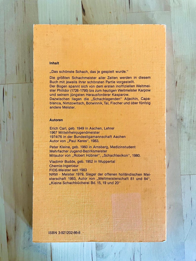 May include: A yellow and orange book cover with the title "Inhalt" and the text "Das sch&ouml;nste Schach, das je gespielt wurde." The book cover also includes the text "Autoren" and lists the authors Erich Carl, Peter Kleine, and Vladimir Budde. The book cover also includes the ISBN number 3-921202-86-8.