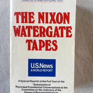 May include: A white paperback book titled The Nixon Watergate Tapes with red text. It features a blue U.S. News & World Report logo and the subtitle A Special Reprint of the Full Text of the Submission of Recorded Presidential Conversations.