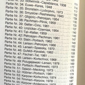 May include: A black and white list of chess games with the names of the players and the year they were played. The list includes games from 1938 to 1978.