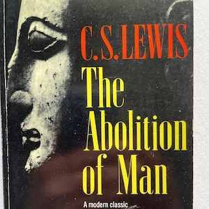 Puede incluir: Portada del libro "The Abolition of Man" de C.S. Lewis. El título está en letras amarillas grandes sobre un fondo negro. El nombre del autor es rojo. A la izquierda, una imagen en blanco y negro de un rostro.