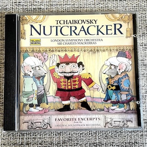 May include: A CD of Tchaikovsky's Nutcracker by the London Symphony Orchestra. The cover art shows a cartoon illustration of a Nutcracker figure in a red uniform and two mice in period clothing. The text reads "Favorite Excerpts".
