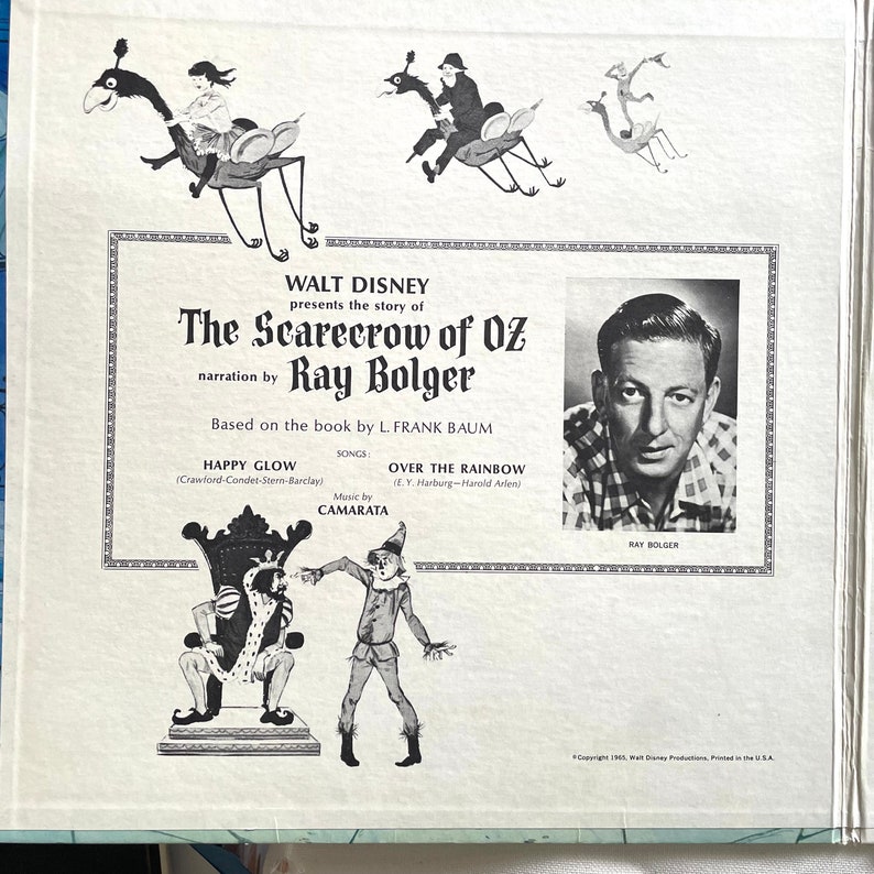 May include: Vintage Walt Disney record album cover for "The Scarecrow of Oz," featuring illustrations of characters and scenes from the story. The cover includes a black and white photo of Ray Bolger, the narrator, and the text "Happy Glow" and "Over the Rainbow."