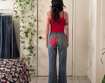 Pantalones vaqueros desgastados de los años 70 con parche de estrella