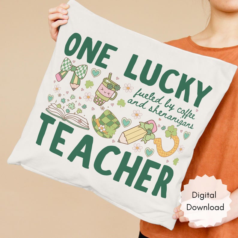 May include: A white pillow with the text "ONE LUCKY TEACHER" in green, along with illustrations of a bow, pencil, coffee cup, hat, and horseshoe. The pillow also has the text "fueled by coffee and shenanigans".
