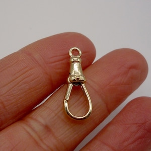 Può includere: Chiusura in metallo dorato con un anello per il fissaggio a una catena o un cinturino. La chiusura ha un design decorativo e una finitura liscia.