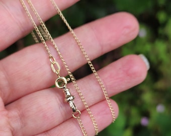 May include: A gold chain necklace with a lobster clasp closure.