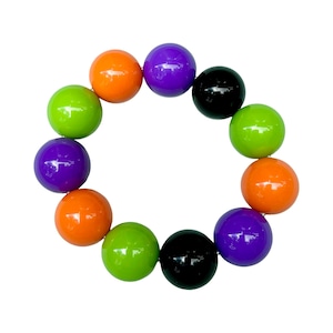 May include: A colorful bracelet made of round beads in shades of green, orange, purple, and black.