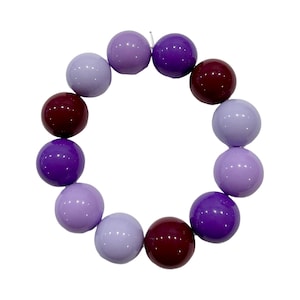 May include: A purple, lavender, and burgundy beaded bracelet with round beads.
