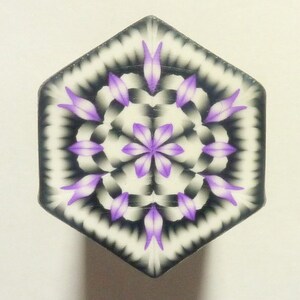 May include: A hexagonal tile with a purple and white mandala design. The mandala features a central flower with eight petals and a repeating pattern of smaller flowers and leaves.