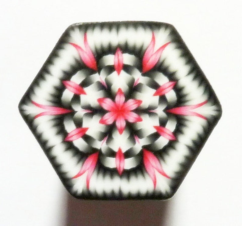 May include: A hexagonal tile with a black and white geometric pattern and a pink flower in the center.