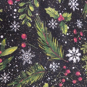 May include: A black fabric featuring a festive holiday pattern of green pine branches, holly leaves, red berries, and white snowflakes. The design includes subtle gold glitter accents scattered throughout the dark background, creating a shimmering effect.