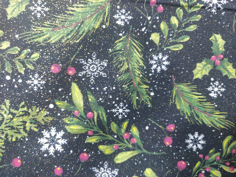 May include: A black fabric featuring a festive pattern of green pine branches, holly leaves, and red berries interspersed with white snowflakes and small gold specks. The design creates a dense, repeating winter-themed botanical print.