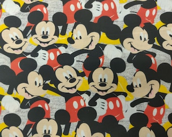 Puede incluir: Una tela gris con un patrón repetido de personajes de Mickey Mouse negros y rojos. Los personajes de Mickey Mouse sonríen y tienen orejas grandes y redondas.