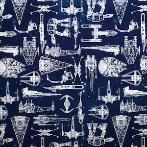 May include: Navy blue fabric featuring a repeating pattern of white spaceship blueprints. The designs include various starfighters and spacecraft, set against a starry background. The overall theme is science fiction.