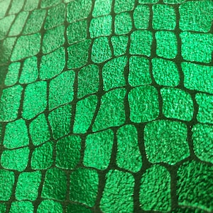 May include: Green fabric with a textured, scaly pattern resembling crocodile skin.