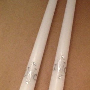 May include: Two white taper candles with the word "I Do" printed in silver on each candle.