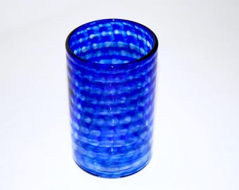 Può includere: Un vaso di vetro blu con un motivo bianco e blu.