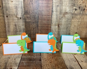 Tarjetas de mesa de dinosaurios: aguamarina, naranja y lima.