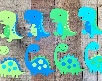 May include: A collection of eight paper dinosaur cutouts arranged in two rows. The top row features four bipedal dinosaurs in shades of lime green and blue, while the bottom row displays four long-necked sauropod dinosaurs in similar colors.