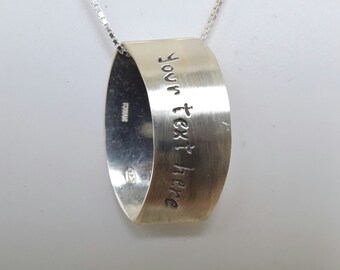 Name necklace silver ring, used as pendant or necklace, apparently flattened with custom text.