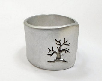 Open aluminum band ring with perforated tree perpendicular to the ring, and custom text.