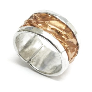 Ring made of aluminum and copper, with a wrinkled and embossed texture. With personalized text.
