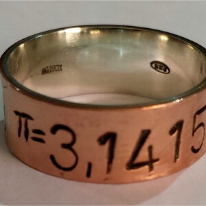 May include: A copper ring with a silver band. The copper band has the mathematical constant pi, "π = 3.14159", engraved on it.