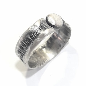 Mens rustic, forged, sterling black silver ring with molten border, and hammered texture of parallel lines.