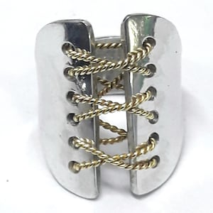 Aluminum ring with brass laces, laces imitating a shoe, with glossy finish.