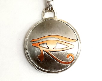 Silver pendant with copper relief of Eye of Horus (egyptian eye).