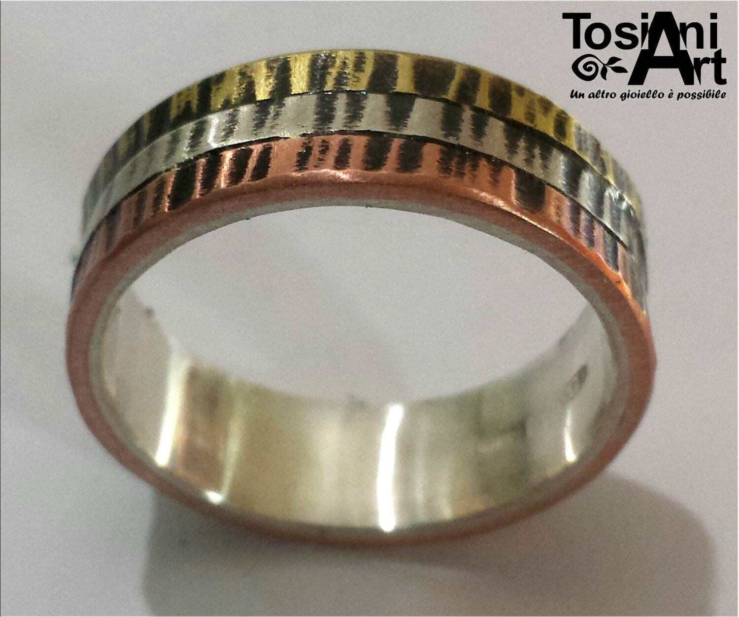 Anillo de compromiso, de plata con tres metales en la parte