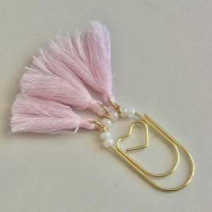 Accessoire d&#39;agenda pour la Saint-Valentin avec un trombone pour carnet de voyage et un signet avec un pompon rose