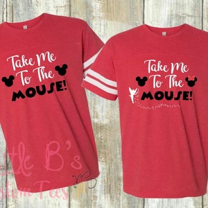 May include: Two red t-shirts with white stripes on the sleeves. The shirts have the text "Take Me To The Mouse!" with a Mickey Mouse and Minnie Mouse graphic.