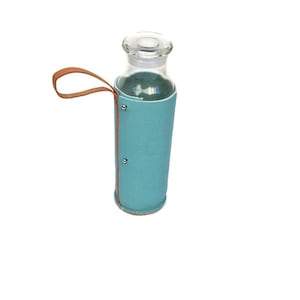 Glass water bottle wrapped in thick blue leather with with glass stopper for hydration, smoothies or juice handmade in Portland Oregon USA