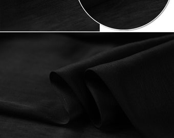May include: Black sheer fabric with a subtle texture. The fabric is folded and draped to show its texture and drape.