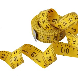May include: A yellow measuring tape with black markings is coiled and uncoiled. The tape reads "Made in China" and has numbers from 2 to 55.