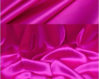 May include: A close-up of a vibrant fuchsia pink satin fabric. The fabric is smooth and silky, with a luxurious drape. The fabric is folded in several places, showcasing its texture and sheen.