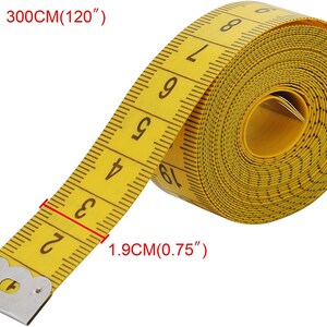 May include: A yellow measuring tape with black markings and a metal end cap. The tape is rolled up and the numbers 2, 3, 4, 5, 6, 7, 8, 9, and 19 are visible. The tape measures 300 cm (120 inches) and is 1.9 cm (0.75 inches) wide.
